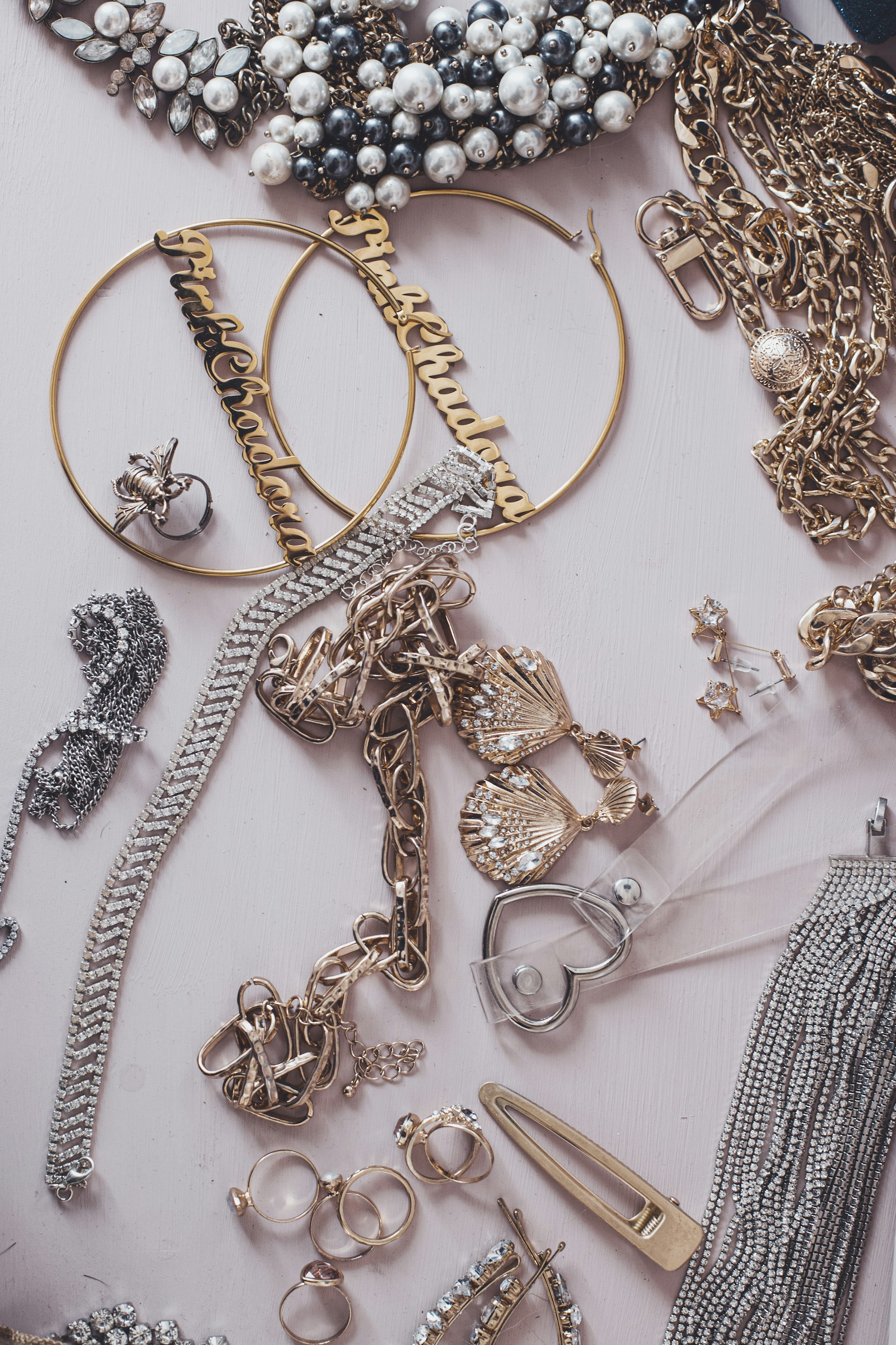 Elegant gold jewelry and burgundy silk fabric close-up, luxury fashion accessories, soft warm lighting, macro photography